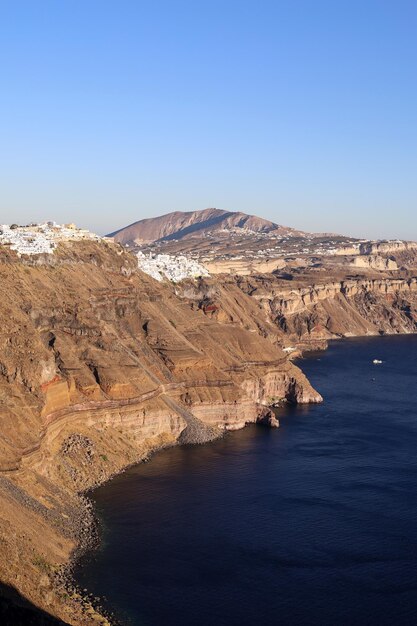 Santorini'de gün batımında beyaz ev ve mavi kubbe — balayı için romantik Ege adası